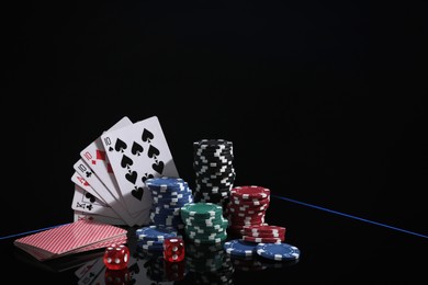 Photo of Casino chips, dice and playing cards on dark background, space for text. Full house poker combination