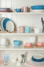 Photo of White shelving unit with set of dishware