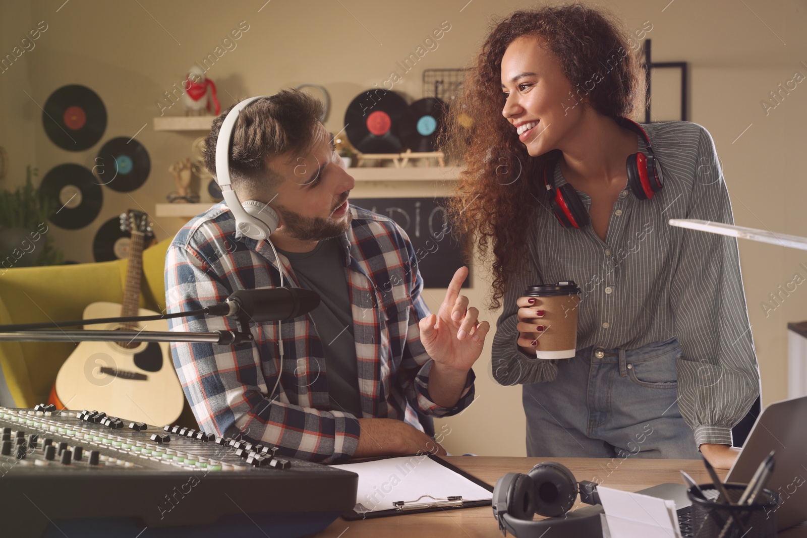 Photo of People working in modern radio studio with professional equipment