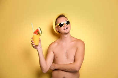 Photo of Shirtless man with glass of cocktail on color background
