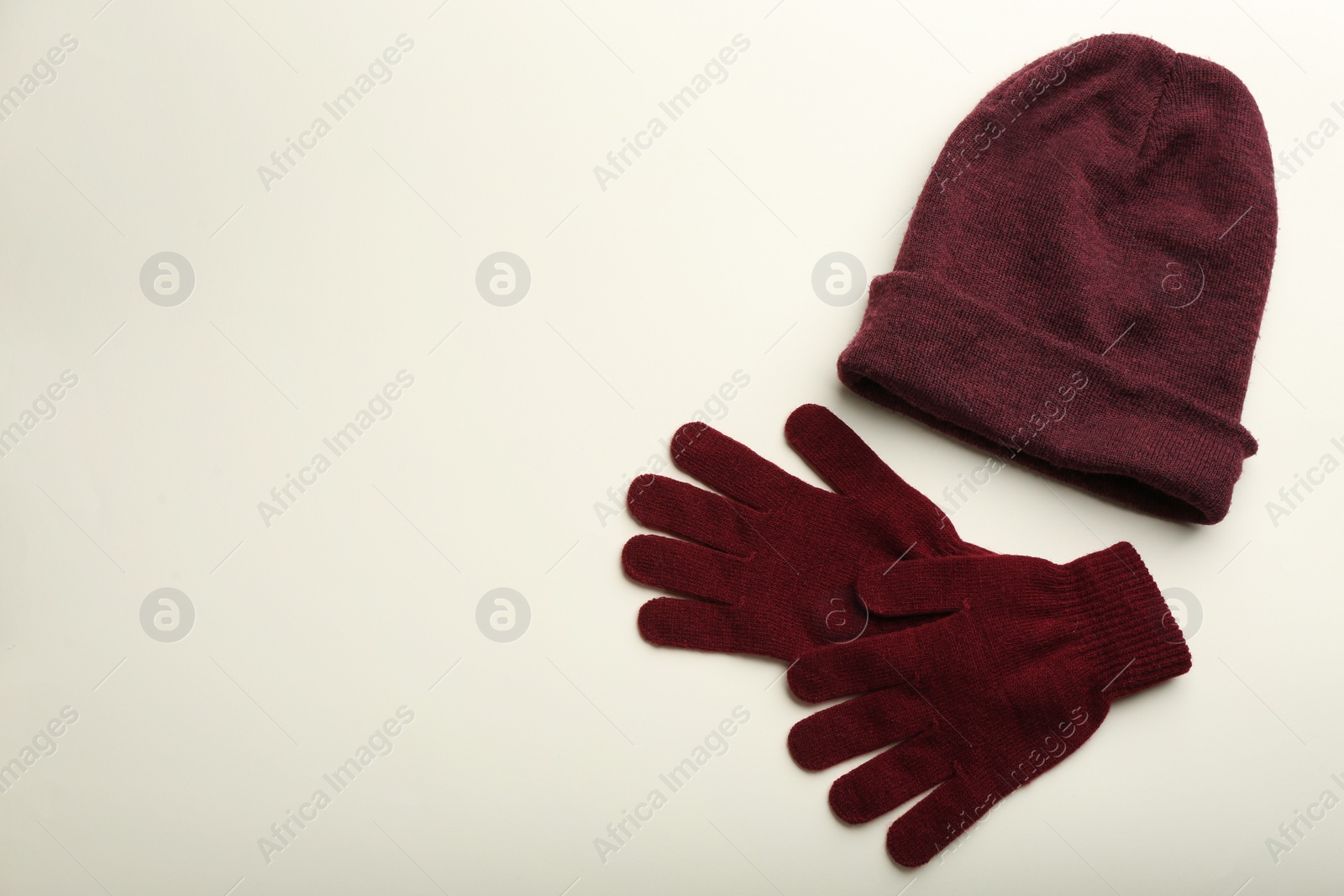 Photo of Woolen gloves and hat on beige background, flat lay. Space for text