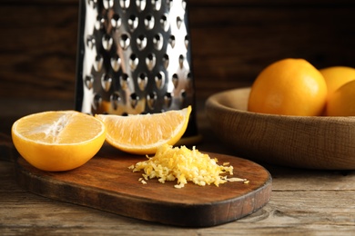 Photo of Grated lemon zest and fresh fruits on wooden table