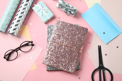 Photo of Flat lay composition with notebooks and gifts on color background. Space for text