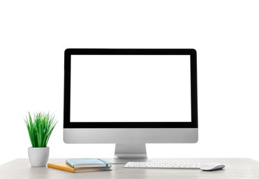 Photo of Computer, potted plant and notebook on table against white background. Stylish workplace