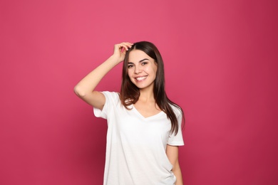 Portrait of young woman laughing on color background