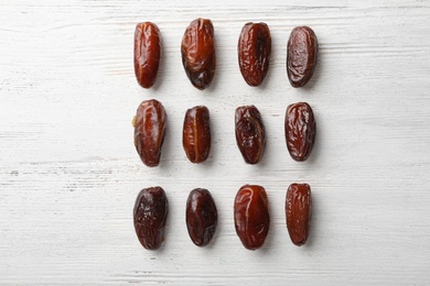 Flat lay composition with dates on wooden background. Dried fruit as healthy snack