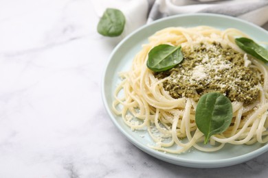 Photo of Tasty pasta with spinach, cheese and sauce on white marble table. Space for text