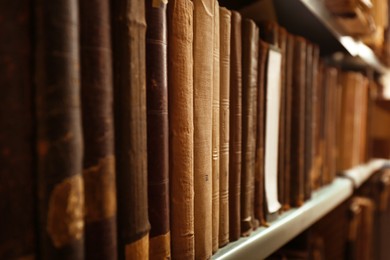 Old books on shelf in library, closeup