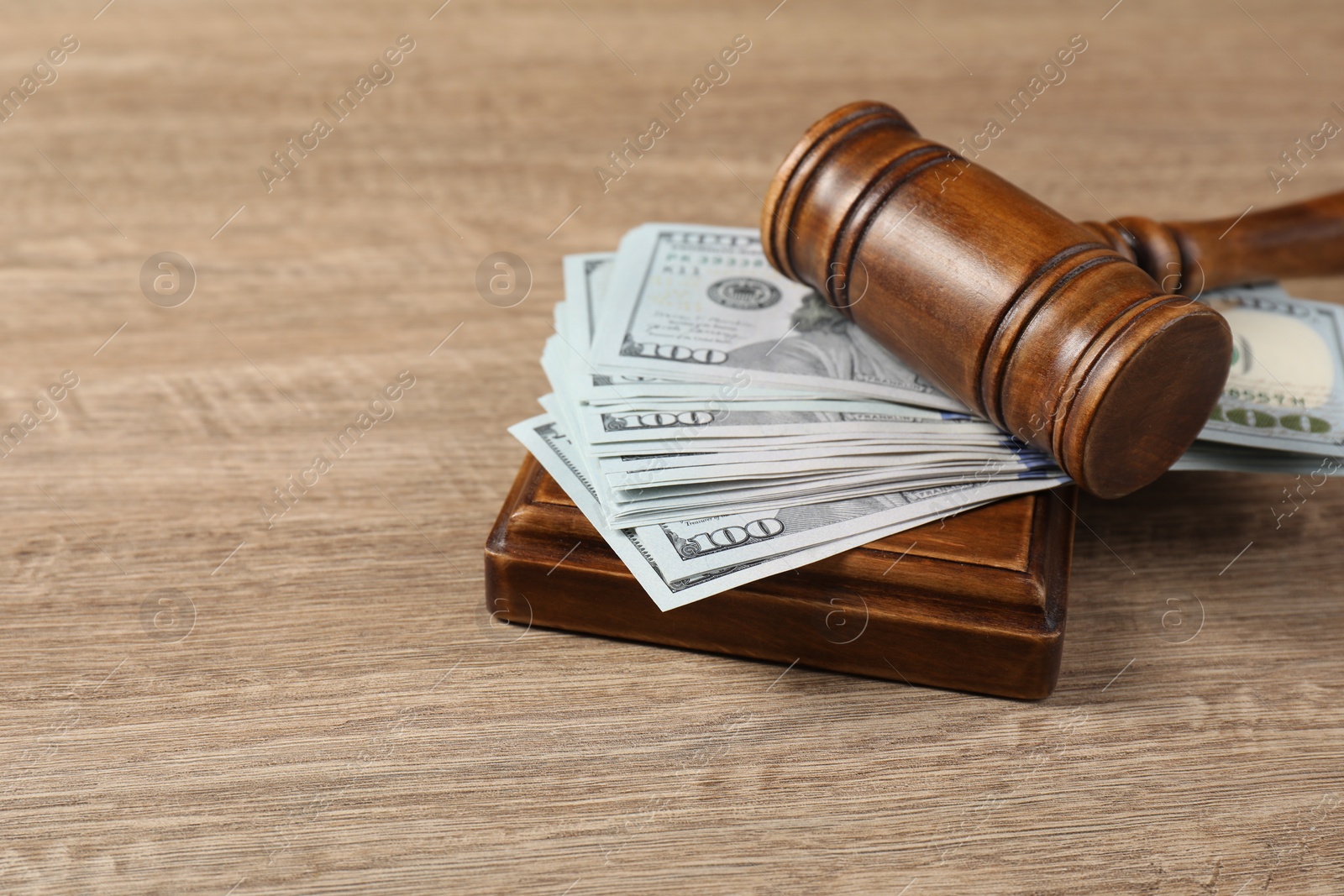 Photo of Judge's gavel and money on wooden table