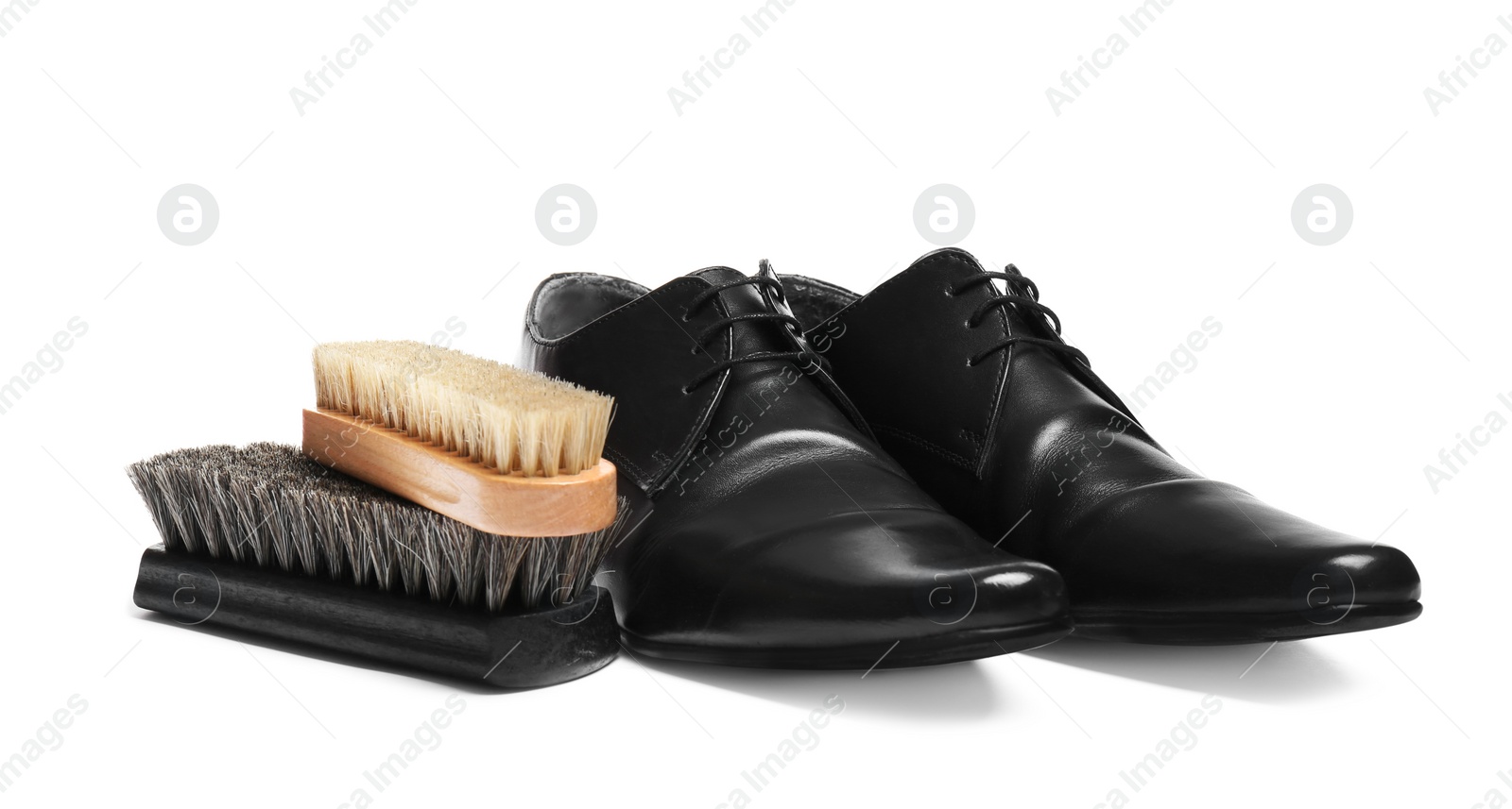 Photo of Stylish men's shoes and cleaning brushes on white background