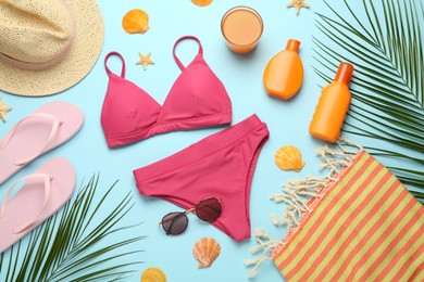 Flat lay composition with different beach objects on light blue background