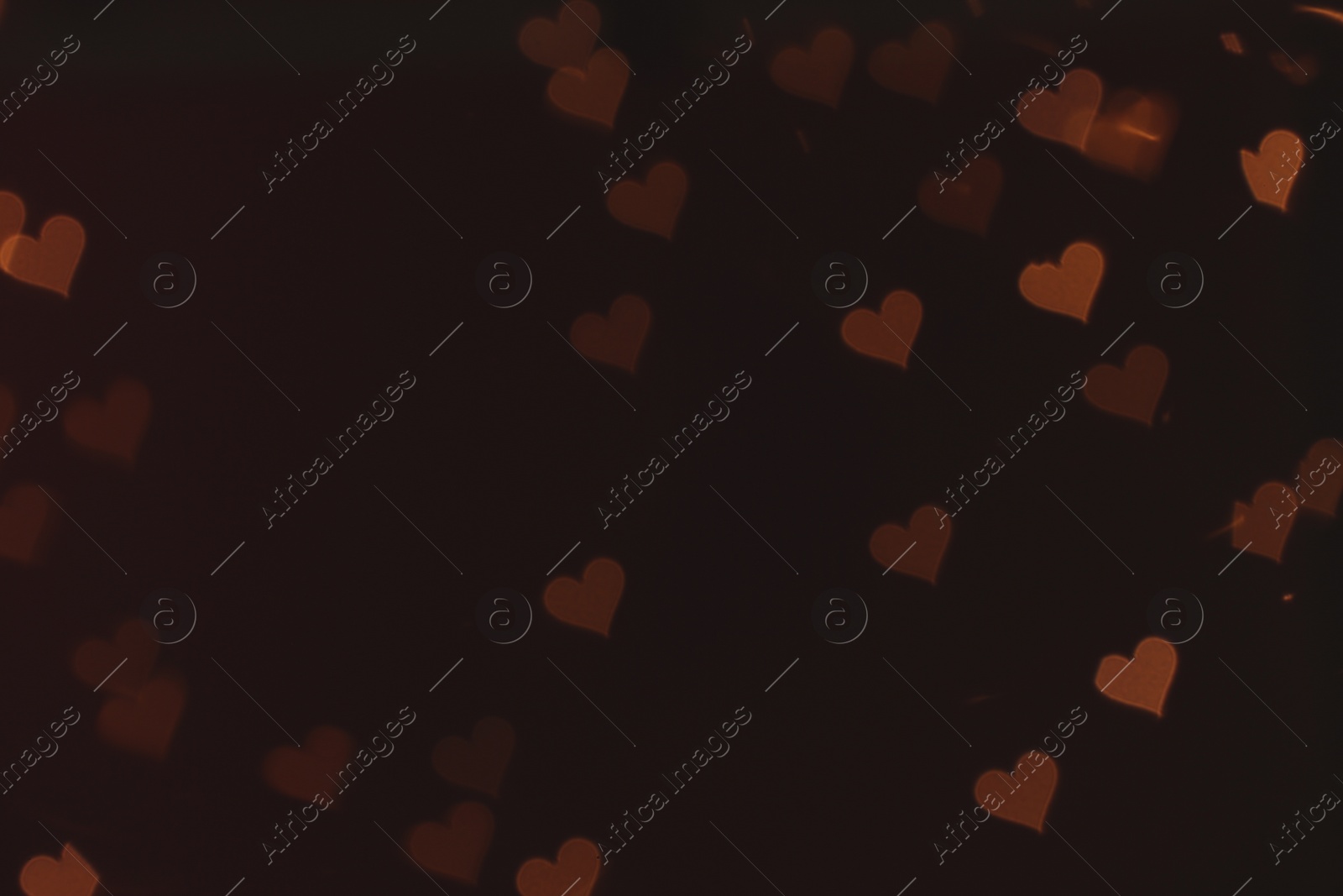 Photo of Blurred view of heart shaped lights on dark background. Bokeh effect