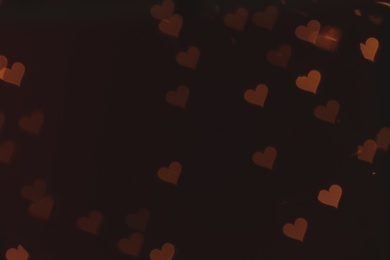Photo of Blurred view of heart shaped lights on dark background. Bokeh effect
