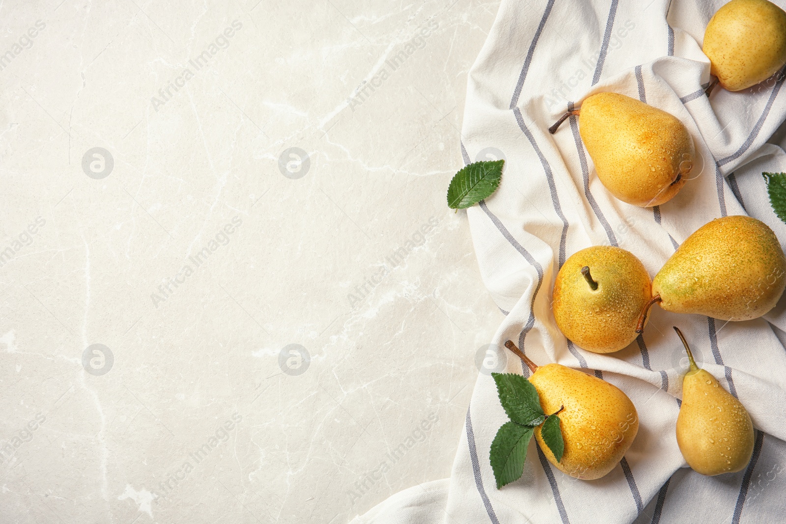 Photo of Ripe pears and striped fabric on grey background, top view. Space for text