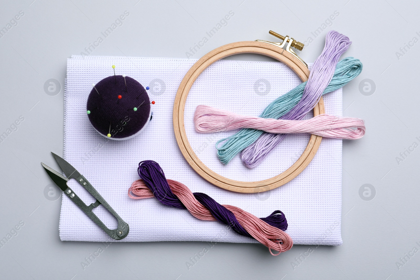 Photo of Set of embroidery equipment on light grey background, flat lay