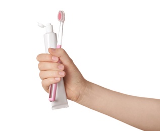 Photo of Woman holding manual toothbrush and paste against white background