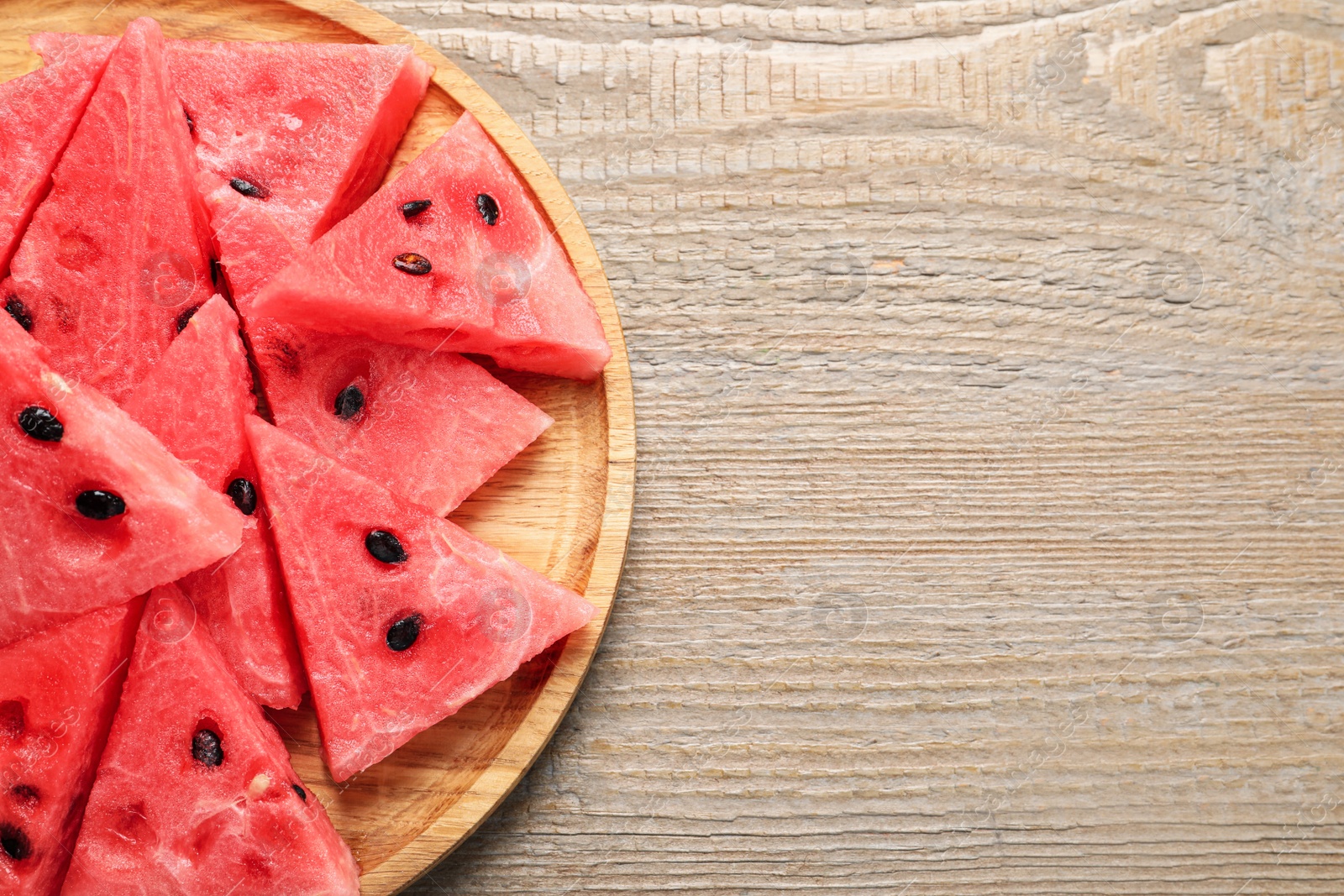 Photo of Delicious fresh watermelon slices on wooden table, top view. Space for text