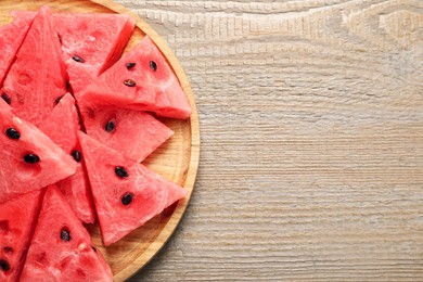 Photo of Delicious fresh watermelon slices on wooden table, top view. Space for text