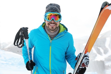 Photo of Man with ski equipment spending winter vacation in mountains