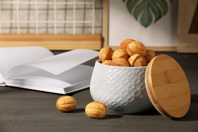 Freshly baked walnut shaped cookies on grey wooden table, space for text. Homemade pastry filled with caramelized condensed milk