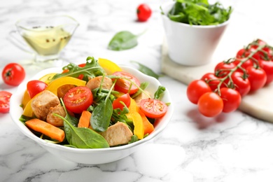 Photo of Delicious fresh chicken salad on white marble table