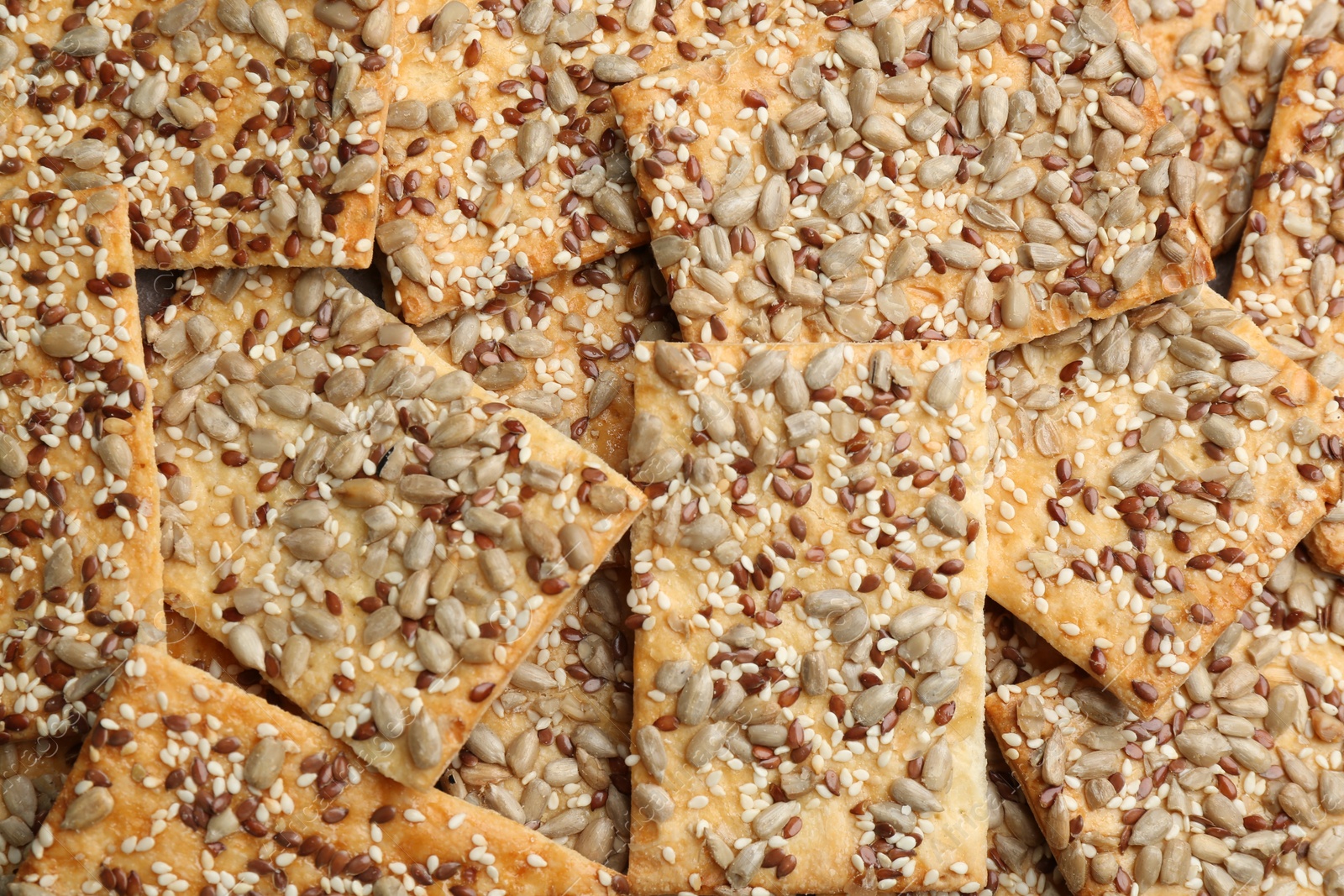 Photo of Many delicious crackers as background, top view