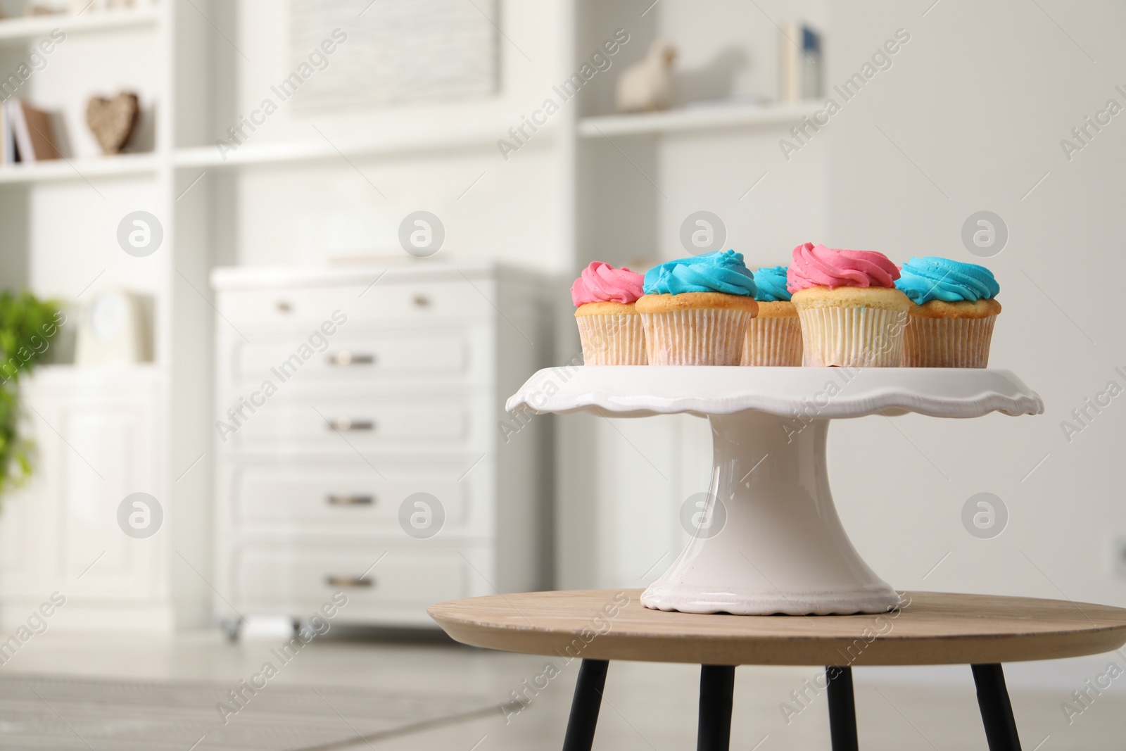 Photo of Delicious cupcakes with bright cream on wooden table indoors