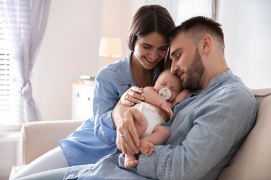 Photo of Happy couple with their newborn baby at home