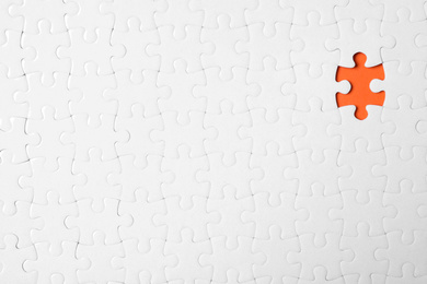 Blank white puzzle with missing piece on orange background, top view. Space for text