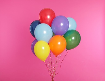 Bunch of bright balloons on color background