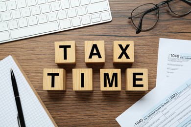 Photo of Flat lay composition with cubes and documents on wooden table. Tax time