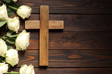 Cross and roses on wooden table, top view with space for text. Religion of Christianity