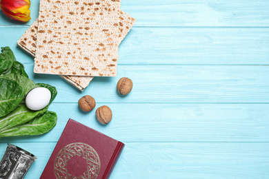 Photo of Flat lay composition with symbolic Pesach (Passover Seder) items on light blue wooden table, space for text