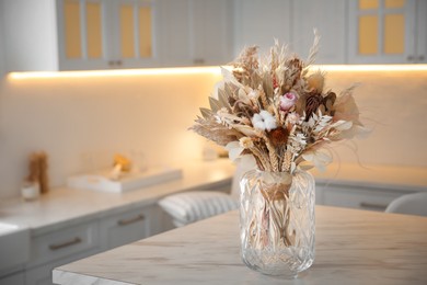 Photo of Bouquet of dry flowers and leaves on table in kitchen. Space for text