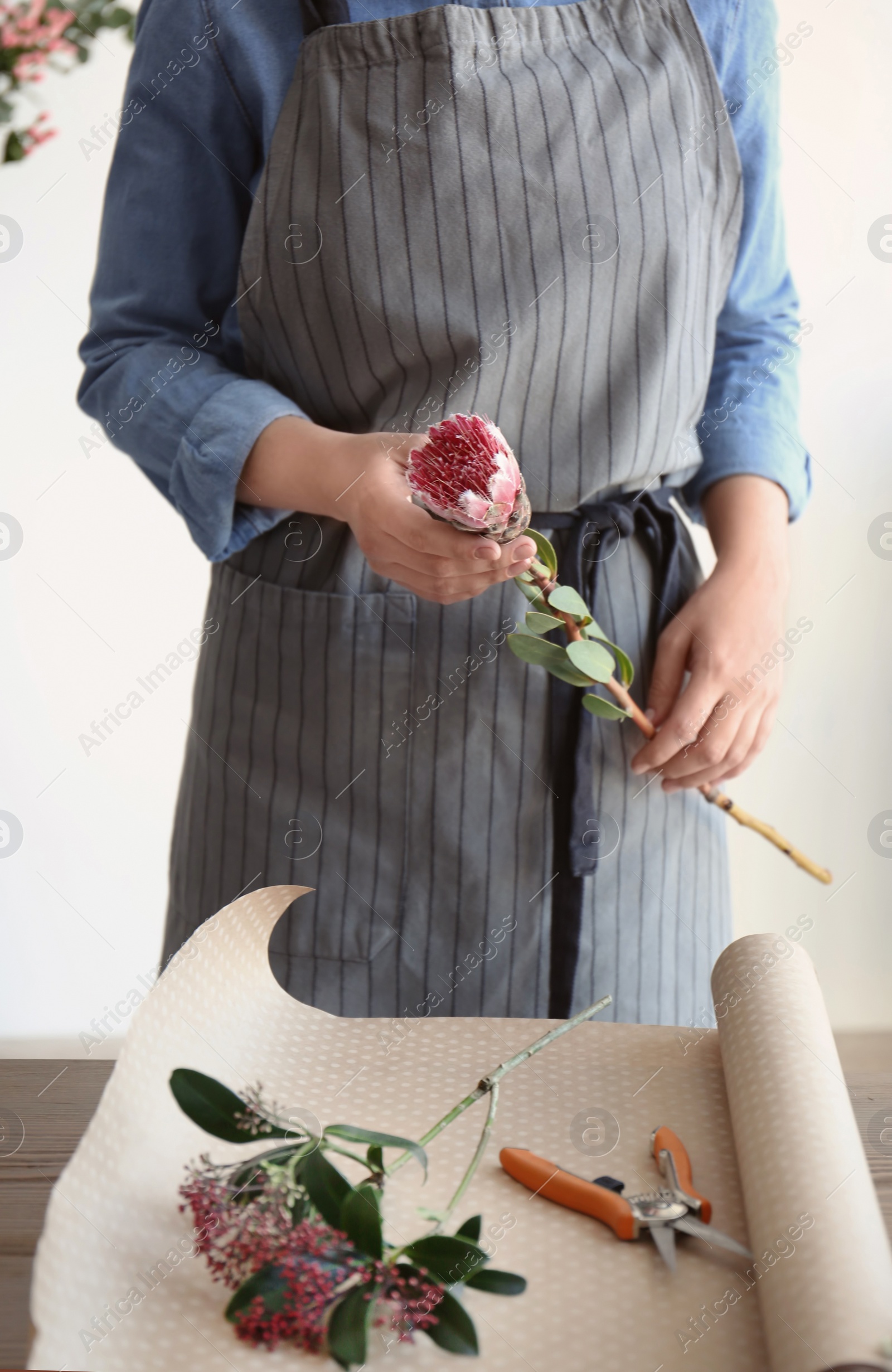 Photo of Female florist creating beautiful bouquet at table