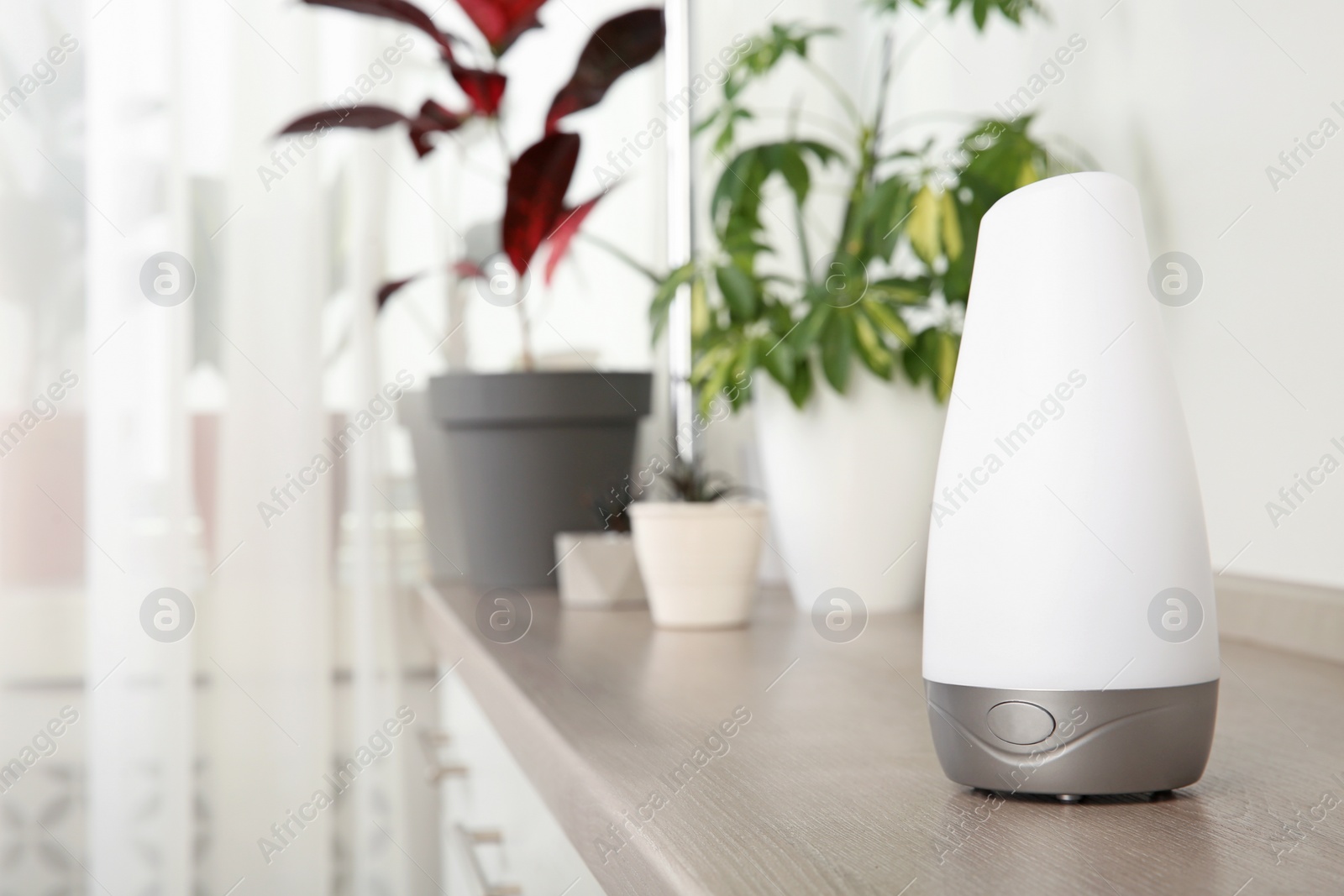 Photo of Composition with modern aroma humidifier on wooden shelf indoors, space for text