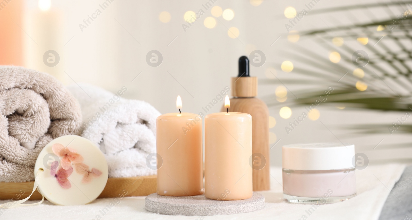 Photo of Spa composition. Burning candles and personal care products on soft surface