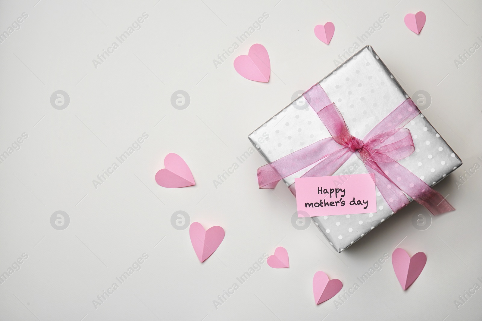 Photo of Flat lay composition with paper hearts and elegant gift box for Mother's Day on light background