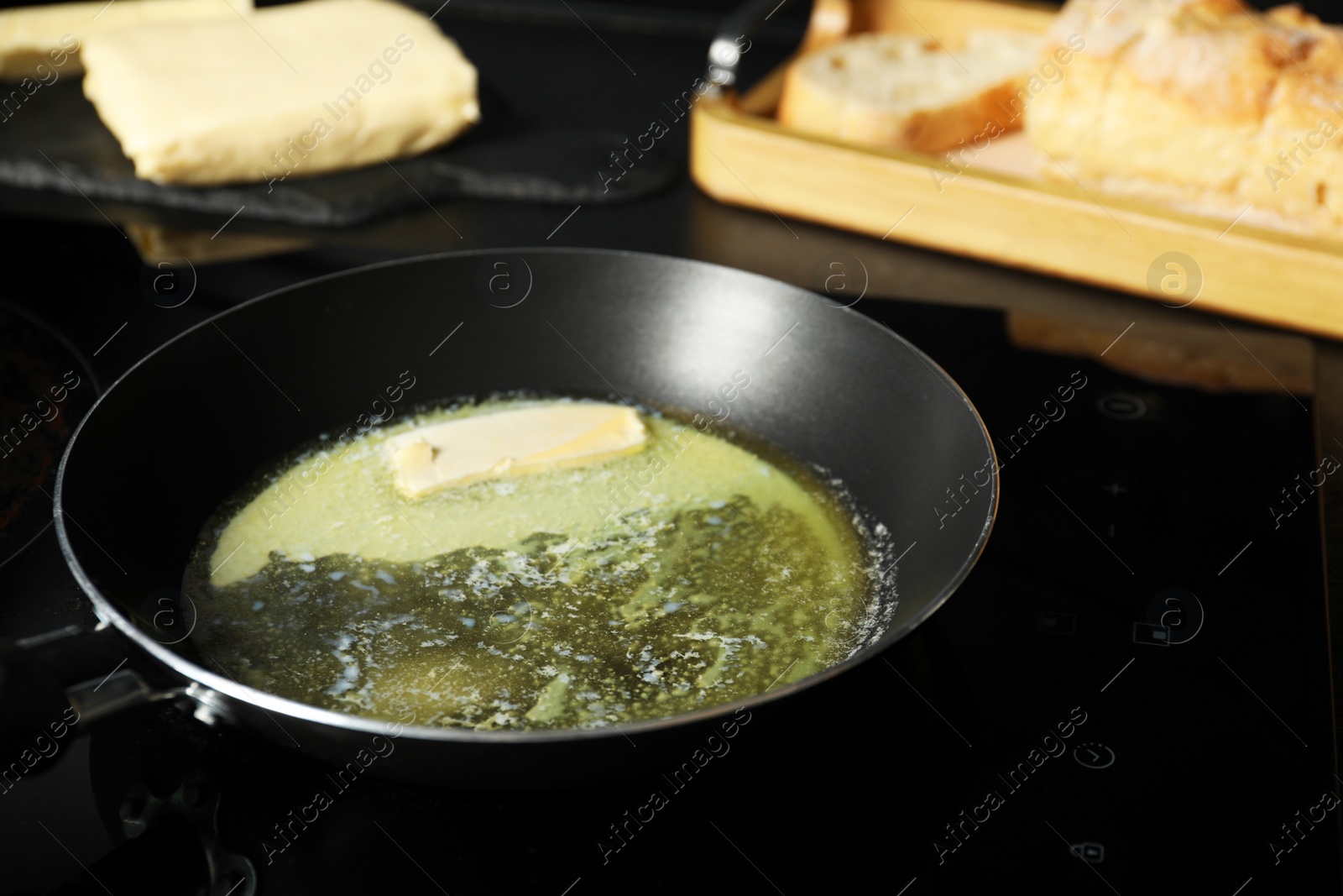 Photo of Melting butter in frying pan on cooktop