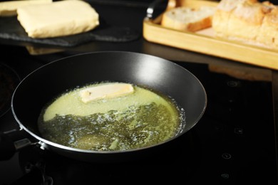 Photo of Melting butter in frying pan on cooktop