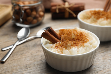 Photo of Delicious rice pudding with cinnamon on wooden table, closeup