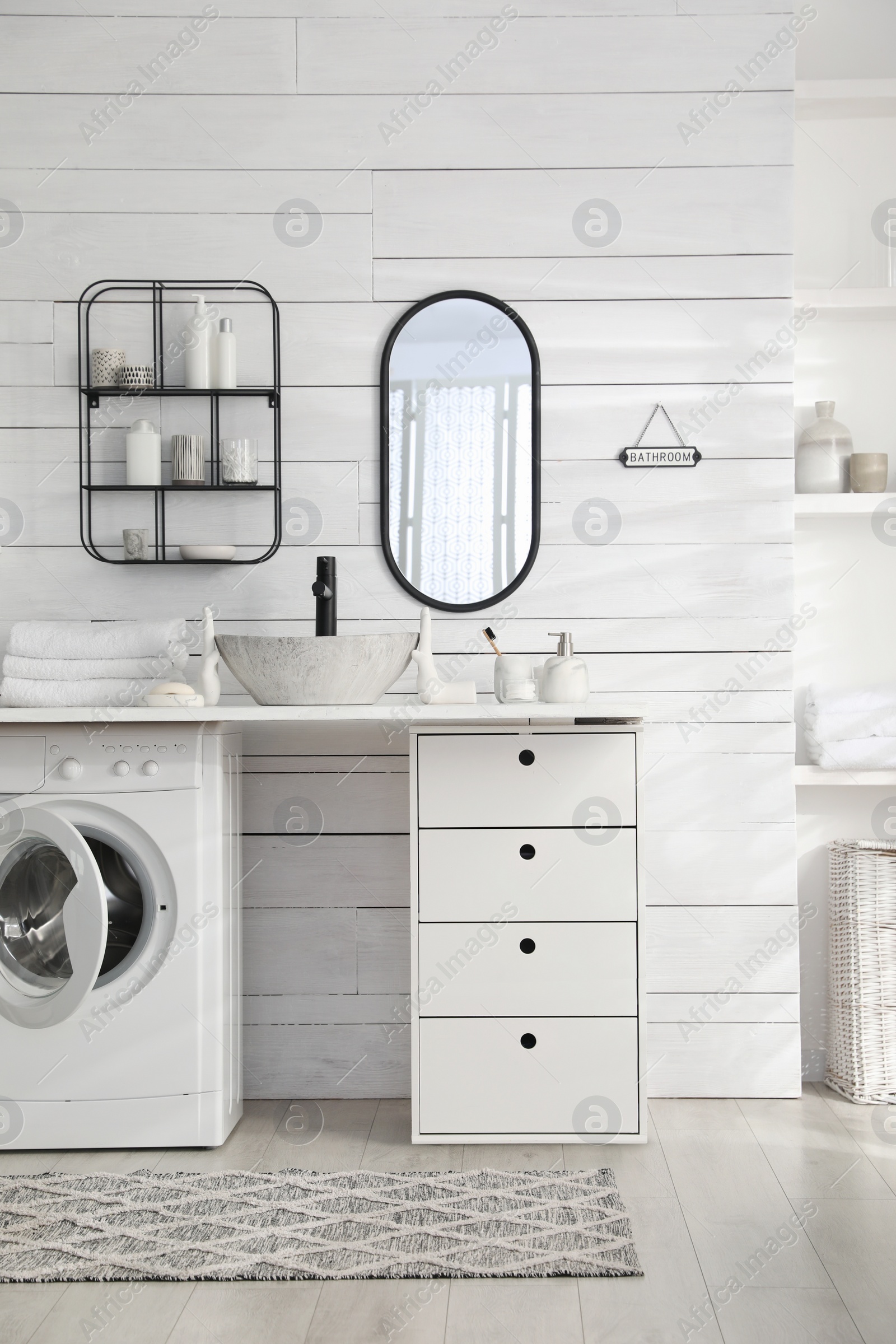 Photo of Stylish bathroom interior with modern washing machine