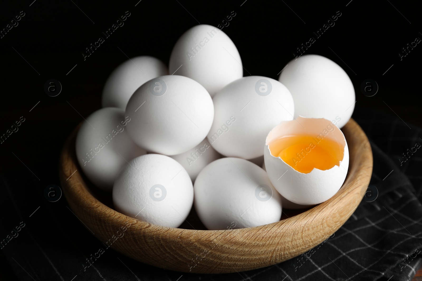 Photo of Many fresh raw chicken eggs in bowl on table