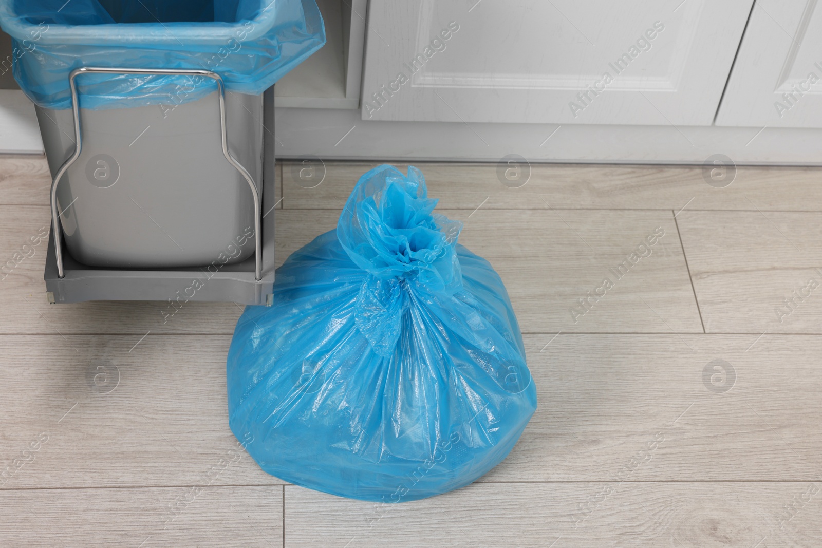 Photo of Plastic garbage bag and trash can in kitchen, above view