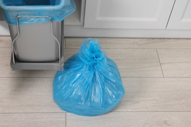 Photo of Plastic garbage bag and trash can in kitchen, above view