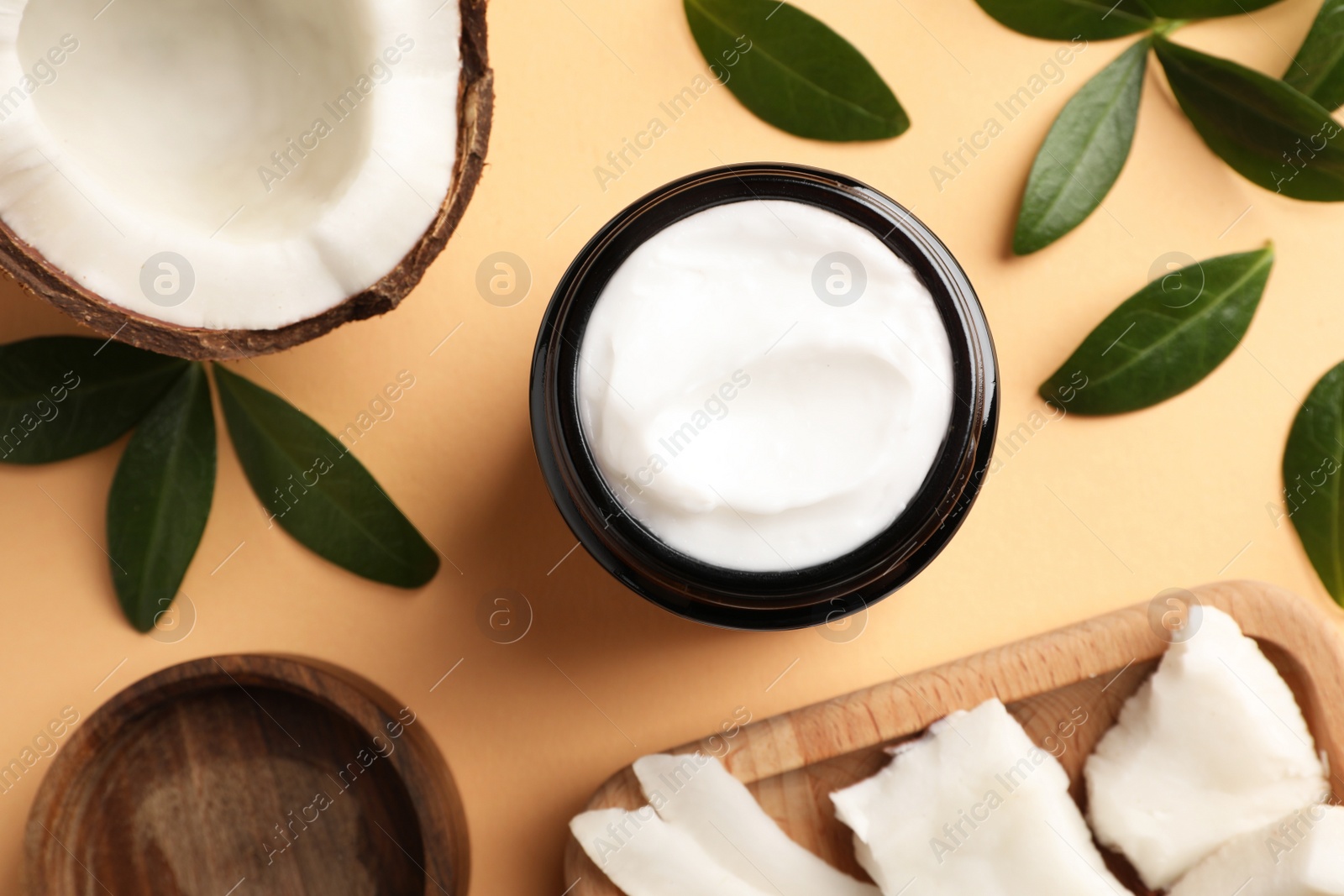 Photo of Flat lay composition with jar of coconut face cream on light orange background