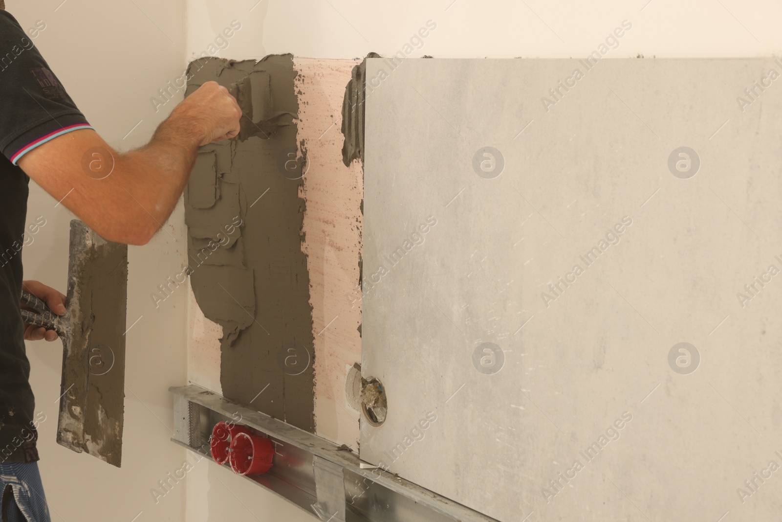 Photo of Worker installing tile in room, closeup. Home improvement