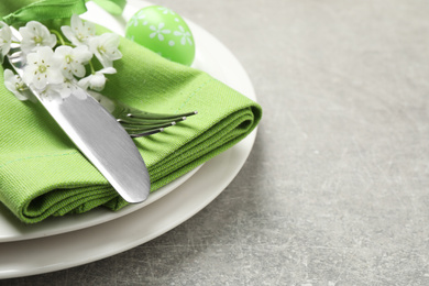 Festive Easter table setting with floral decor on grey background, closeup