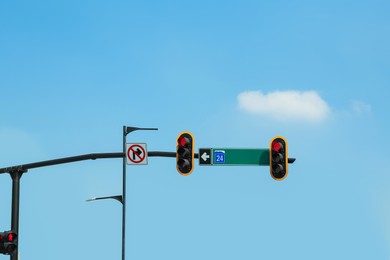 Photo of Traffic lights with red sign on city street. Road rules