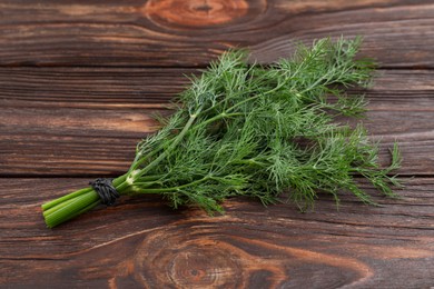 Photo of Bunch of fresh dill on wooden table, top view